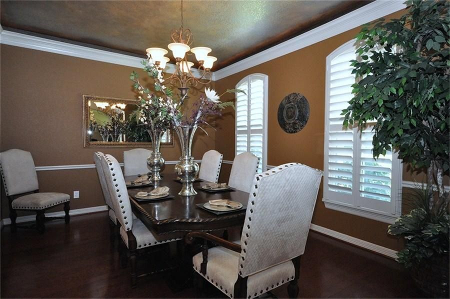 Eclectic Dining Room with Chandelier, Standard height, Laminate floors, Crown molding, Chair rail, Casement