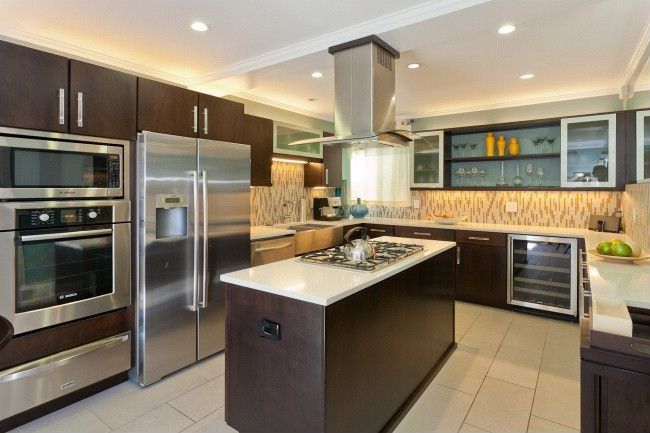 Contemporary Kitchen with Kitchen island, Wine refrigerator, wall oven, full backsplash, stone tile floors, Crown molding