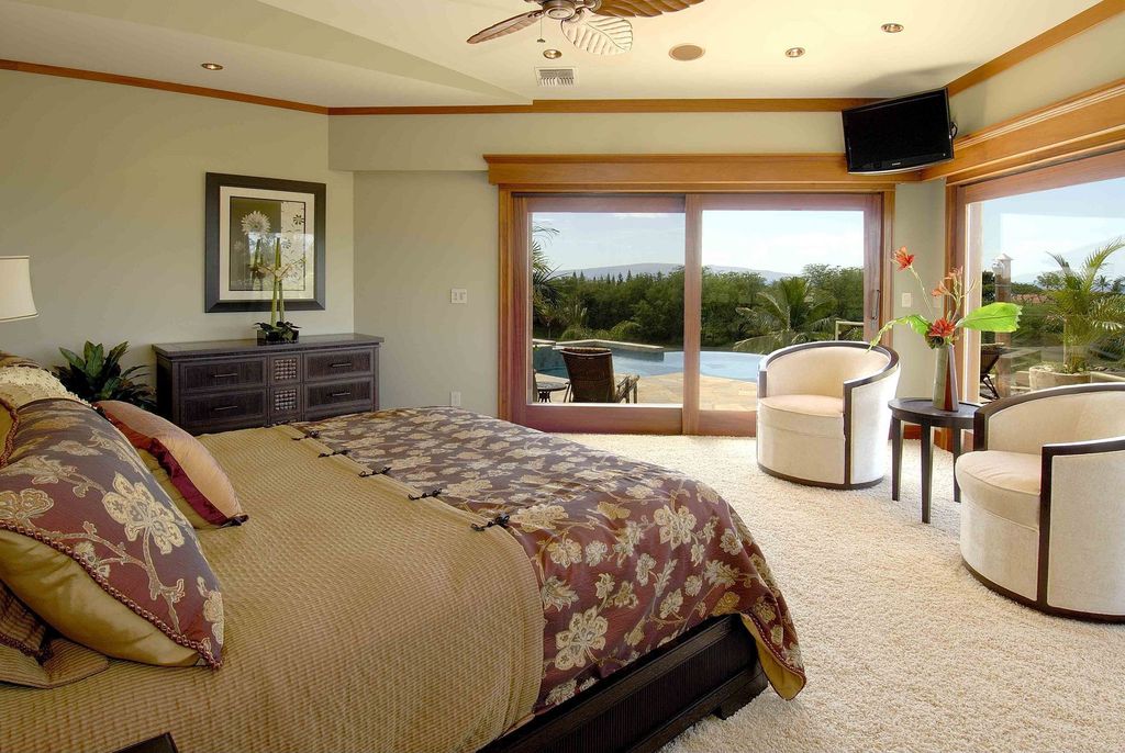 Tropical Guest Bedroom with Ceiling fan, sliding glass door, can lights, Standard height, picture window, Carpet