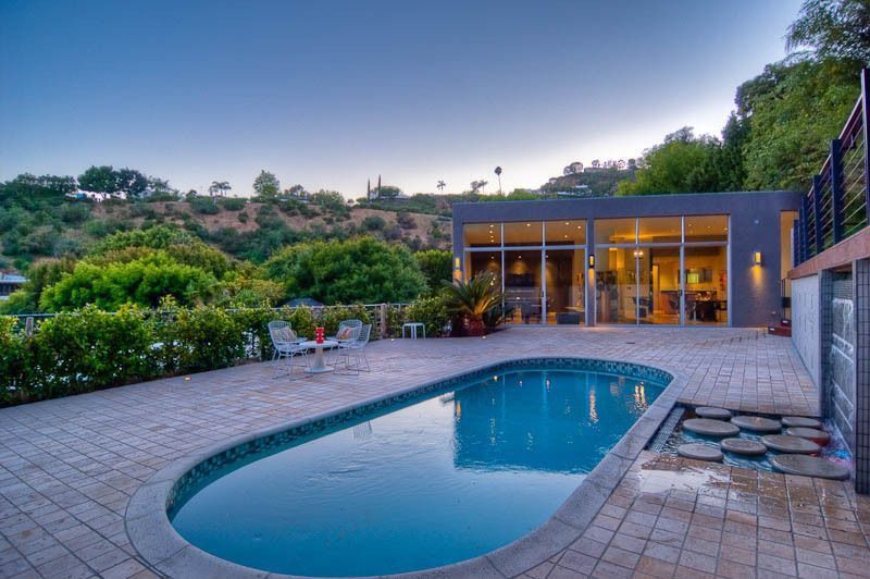Contemporary Swimming Pool with exterior stone floors, sliding glass door, Transom window, Fence, Other Pool Type