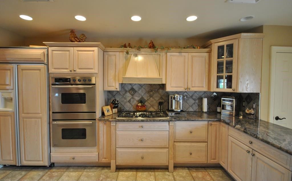 Country Kitchen with Complex granite counters, can lights, Glass panel, Stone Tile, limestone tile floors, Paint 1, L-shaped