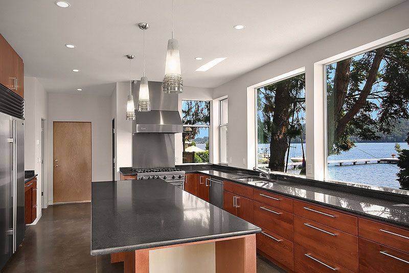 Contemporary Kitchen with Built In Refrigerator, Kitchen island, Simple granite counters, dishwasher, can lights, flat door