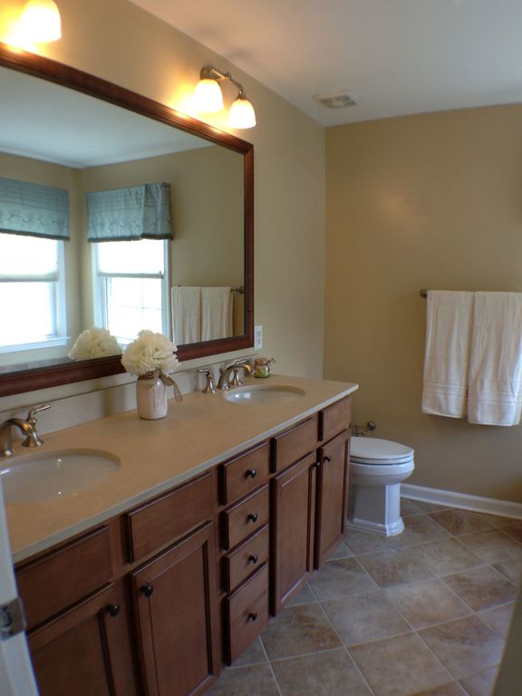 Traditional Master Bathroom with Double sink, Flat panel cabinets, Undermount sink, limestone tile floors, Limestone counters